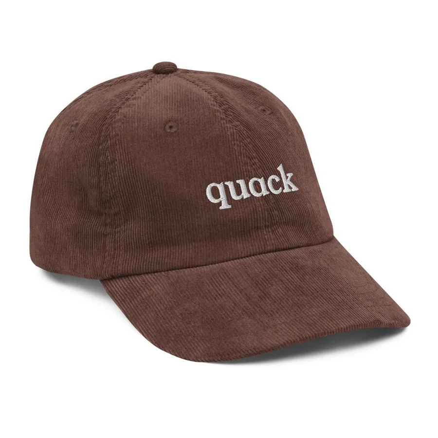 Brown corduroy dad hat with the word quack embroidered in white lowercase serif